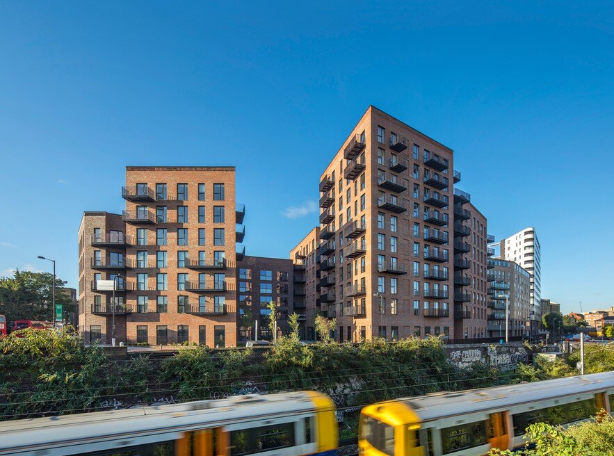 Dalston Works viewed across the railway, showing its red-brick residential buildings above the commercial campus